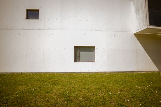 A white building wall and surrounding grass