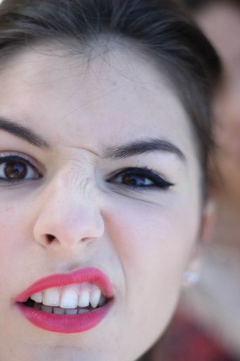 A vertical closeup shot of a female with a funny expression and a scrunched nose