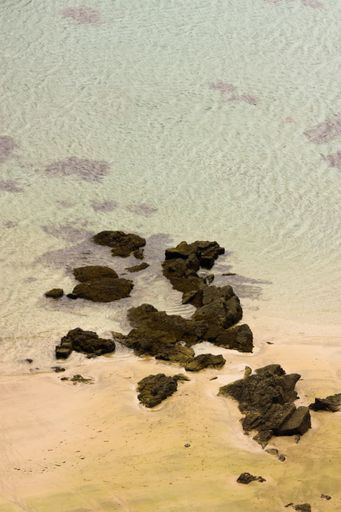 A vertical shot of small rock formations in the sea