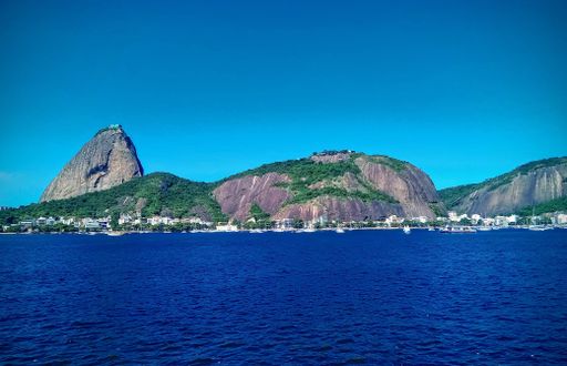 An aerial view of sea with beach surrounded by buildings in Rio de Janeiro