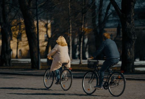 A happy young couple enjoying a leisurely bike ride together on a sunny day