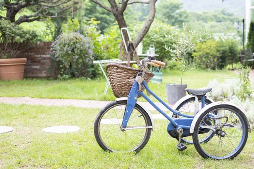 A blue bike with a basket on a field