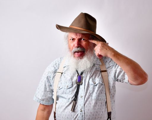 An angry and frustrated senior Caucasian male in a hat on white background