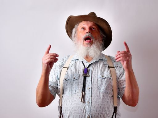 A senior Caucasian bearded male looking up and praying on white background