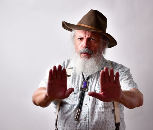 A senior Caucasian bearded male showing stop gesture on white background