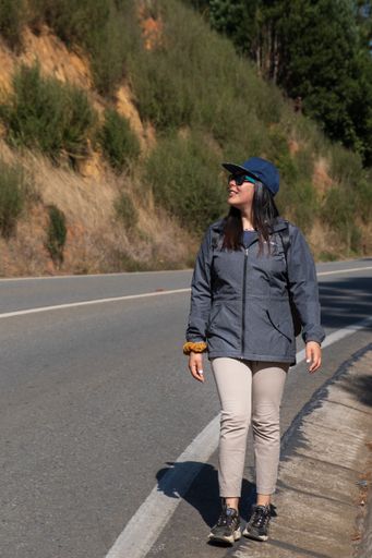 woman walking on the road looking at the sky, vertical shot