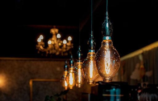 A row of light bulbs hanging from the ceiling in the dark room.