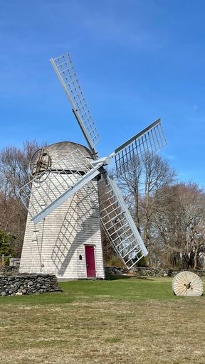 A majestic windmill in a lush green grassy field in Jamestown