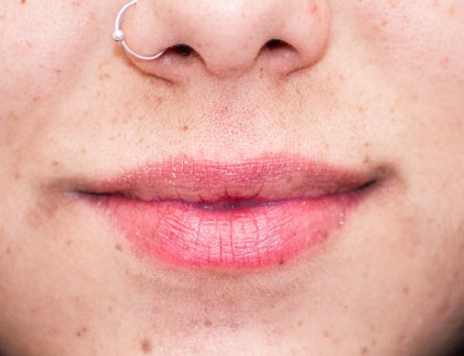 A  close-up of a young adult female with a nose piercing