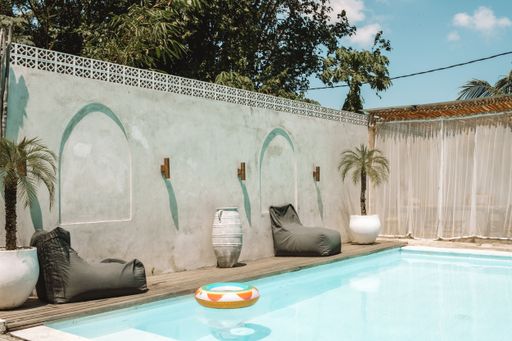 Beautiful exterior of a Bali villa with a swimming pool and palm trees.