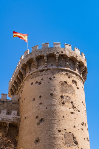 Torres de quart with the flag of Spain waving on a clear day in Valencia, Spain. Vertical shot