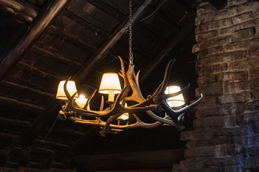 A close up shot of a chandelier made of horns in old cabin