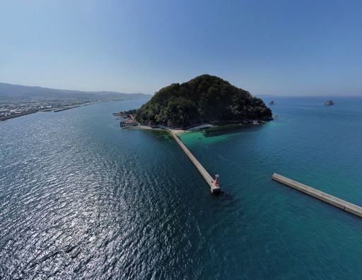 An aerial view of a small island covered with greenery in Japan on a sunny day