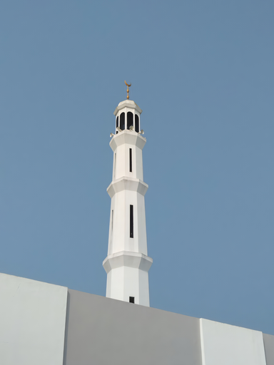 A white mosque tower against a blue cloudless sky.