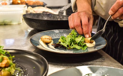A professional chef hard at work in a commercial kitchen, preparing a delicious meal