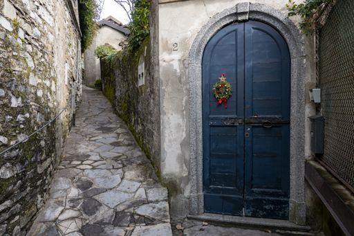 A blue weathered wooden door near the narrow alley