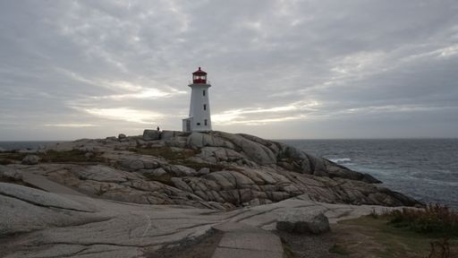 A beautiful view of the Peggy's Point Lighthouse in the background of the gloomy dramatic sky