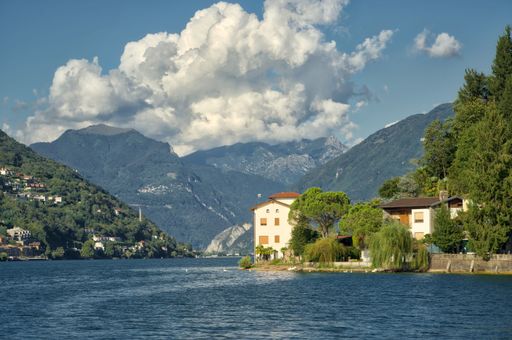 An aerial view of Lake Lugano in Switzerland, surrounded by lush green mountains