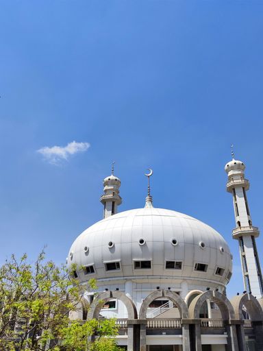 The facade of the white Xiguan Mosque against a blue sky
