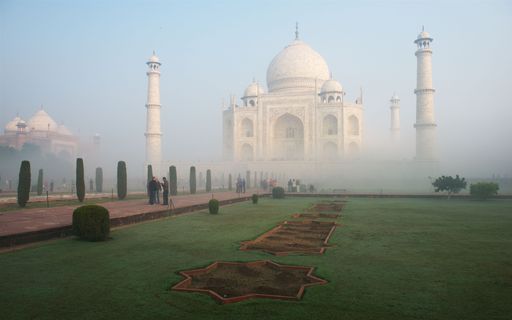 the iconic Taj Mahal, the white marble mausoleum located in Agra, India, shrouded in a thick fog