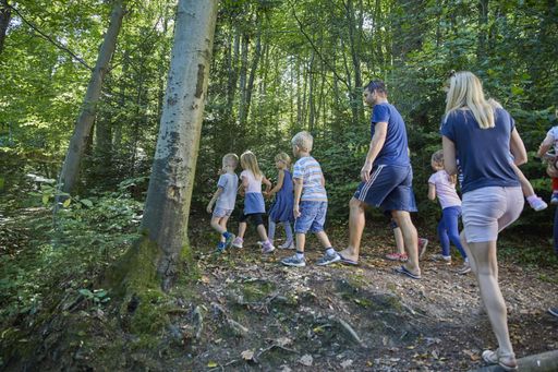 Young children discover and explore beauty of nature in a green resort forest.