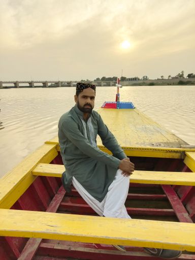 man sitting on colorful wooden boat,evening view at head Saifan melsi Pakistan,tourism and picnic point