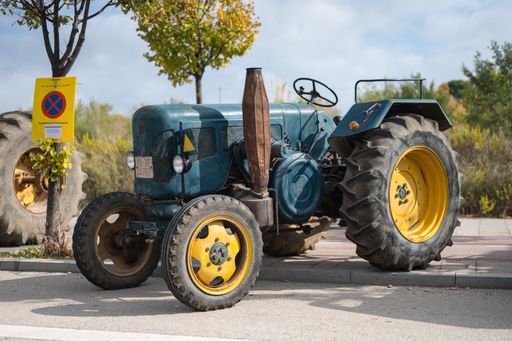 Front view of a nice classic tractor, it is a green Lanz with yellow wheels parked in the street