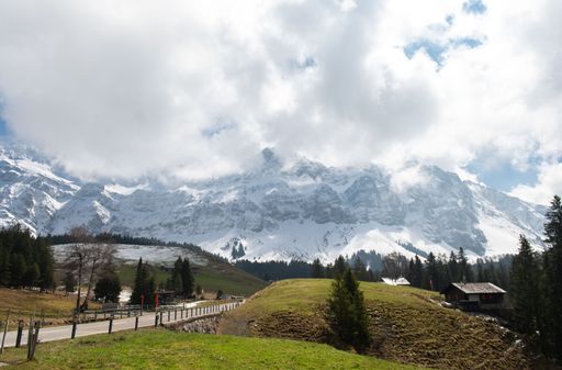 A scenic view of the Santis mountain with a highway road and a small house in the foreground