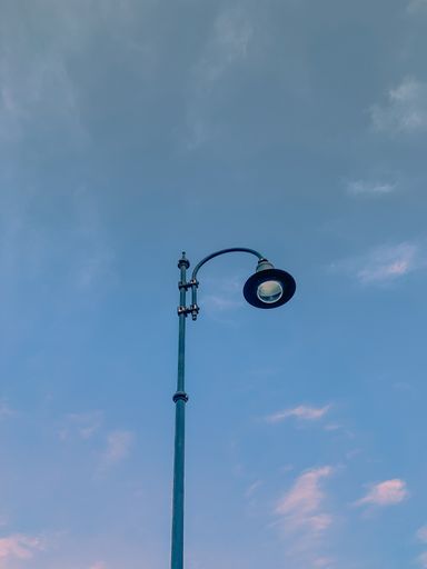A vertical shot of street lights during a cloudy day