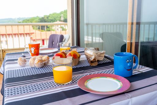 A cozy outdoor seating area with a wooden table with breakfast ready to be enjoyed