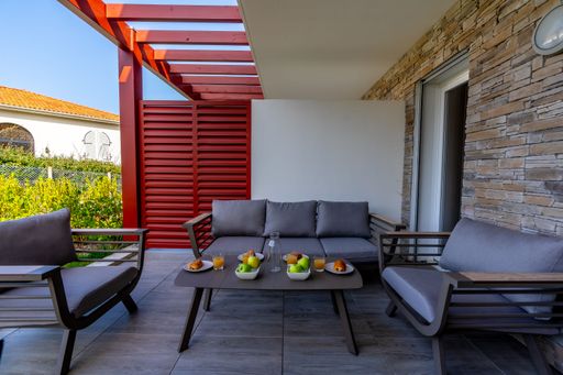A cozy outdoor seating area with a wooden table with breakfast ready to be enjoyed
