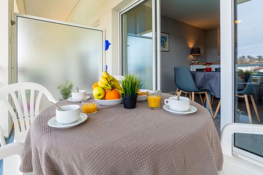 A cozy outdoor seating area with a wooden table with breakfast ready to be enjoyed