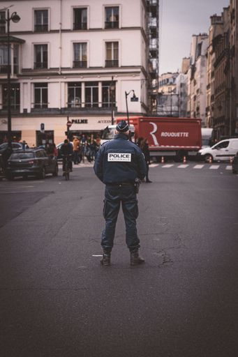 A vertical rear view of a policeman on the street during a protest riot in Paris, France