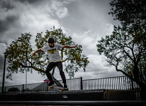A young skateboarder performing an ollie trick, mid-air in a park setting