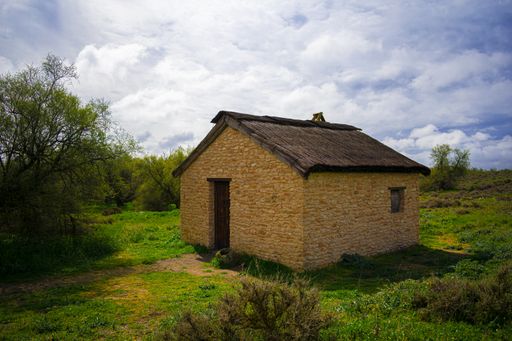 A horizontal shot of a brick house in the middle of a field, Tablas de Daimiel National Park, Spain