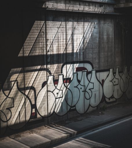 A wall in Pisa featuring graffiti artwork illuminated by sunlight