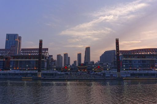 A wide angle shot of several skyscrapers next to each other in front of the water