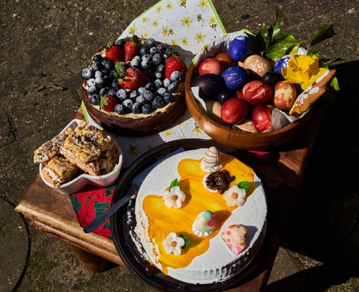A rustic wooden table with Easter sweets and painted eggs