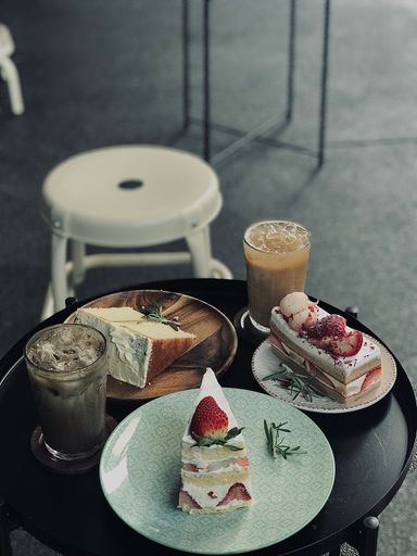 A cafe table with an array of desserts and a cup of coffee, creating a delectable atmosphere for guests