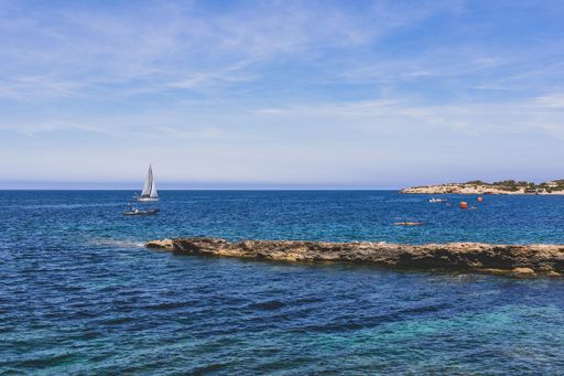 A stunning coastal scene of a boat anchored near a shoreline under the blue sky