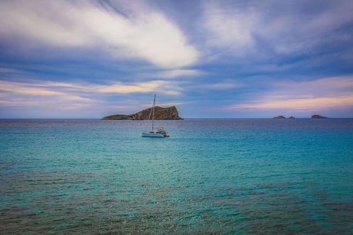 A stunning coastal scene of a boat anchored near a shoreline under the blue sky