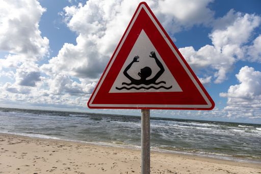 A warning sign alerting swimmers of the potential risks of swimming in the ocean