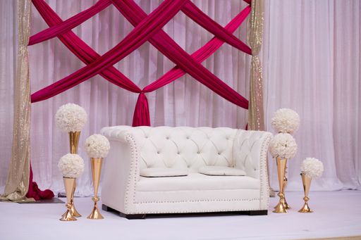 A white couch decorative stands before a wall with flowers