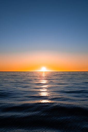 A vibrant vertical shot of the sun setting over the Atlantic Ocean