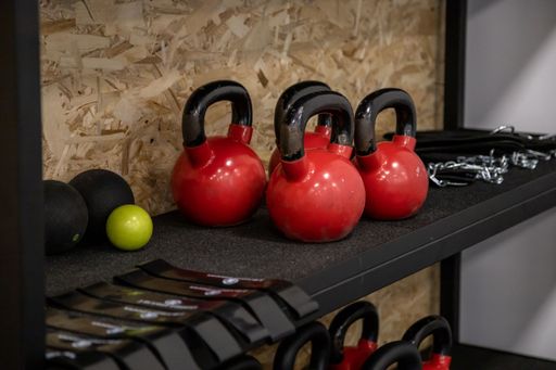 A closeup of dumbbells arranged on a shelf in a gym