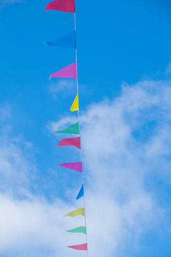 A vertical of colorful flags against the blue sky