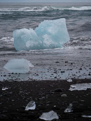 The icebergs with small pieces floating on top of them on Diamond beach