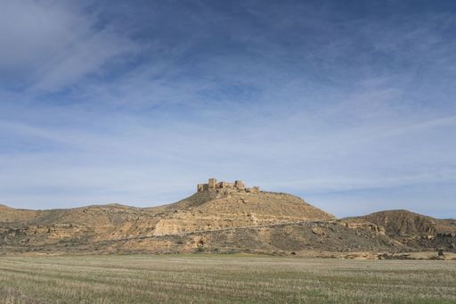 Paranoramic of a passage with a mountain on the horizon and a castle called Montearagon which is located in huesca with a clear sky and some cloud.