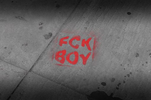 A vibrant red graffiti "FCK BOY" painted onto a concrete wall