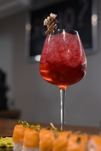 A vertical shot of a cold cocktail served with sushi